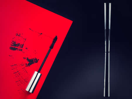 reflex mascara on black background and mascara brush stroke on red backgroundの写真素材