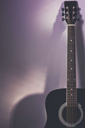 Black acoustic guitar in a vintage lights and colors moodの写真素材