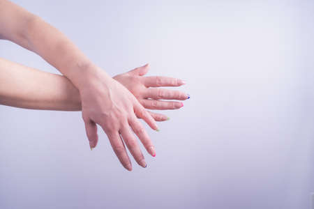 woman hands with nails painted with glossy nail polish and colored french on white background in horizontal shotの写真素材