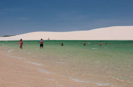 Tourists in lagoons surrounded by dunes in the LenÃ§ois Maranhenses National Park, MaranhÃ£o, Brazilのeditorial素材
