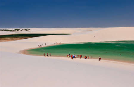 Tourists in lagoons surrounded by dunes in the LenÃ§ois Maranhenses National Park, MaranhÃ£o, Brazilのeditorial素材