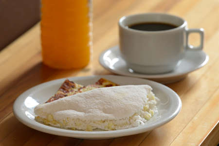 Gastronomy. Cheese and coconut tapioca, a typical food from the northeast region of Brazil, made with manioc flour, alongside a cup of coffee and organic butter