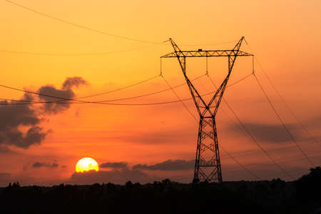 Electricity transmission tower with sunset in the background.の写真素材