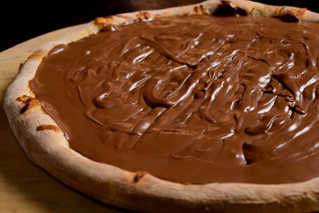 Chocolate pizza on wooden board. Brazilian sweet pizza.の写真素材