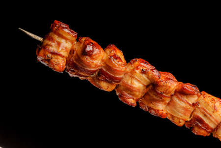 Barbecue turkey breast with bacon on skewers on black background. Brazilian gastronomy.の写真素材