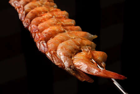 Shrimp barbecue on skewers on black background. Brazilian gastronomy.の写真素材