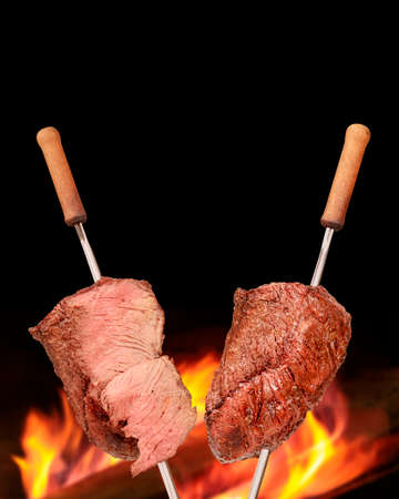 Barbecued Picanha barbecue with blurred fire in the background. Also called churrasco.の写真素材