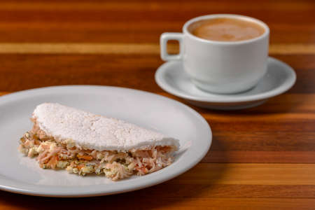 Tapioca on white plate on wooden table. Brazilian food.の写真素材