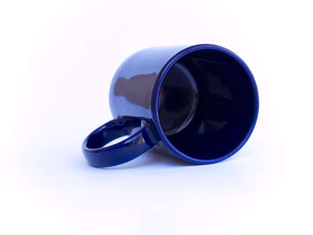 Blue coffee cup under soft focus laying down on white.