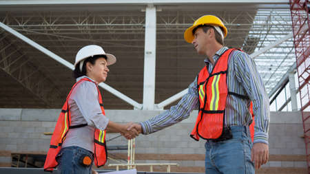 Male and Female Workers Shake Hands