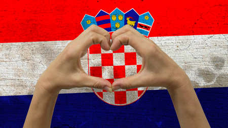 With a stylized Croatian flag background an anonymous person's hands being held in the form of a...