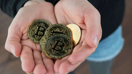A close up shot of a woman holding her Bitcoin cryptocurrency filled hands open.の写真素材