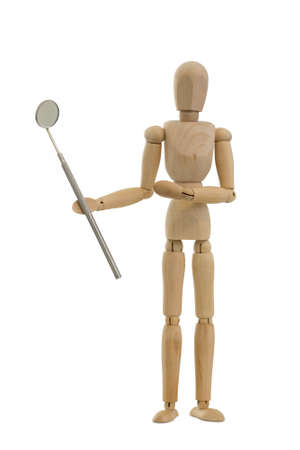 Wooden mannequin or figurine holding a dental mirror on a white background.の写真素材