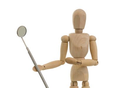 Close up bust of a wooden mannequin or figurine holding a dental mirror on a white background.の写真素材
