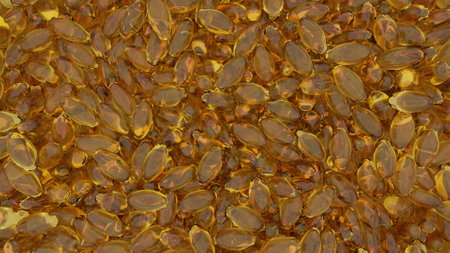 Overhead shot of many yellow soft capsules or gelcaps that are used for medicines, dietary supplements or vitamins in the health, well-being and medical industry.の写真素材