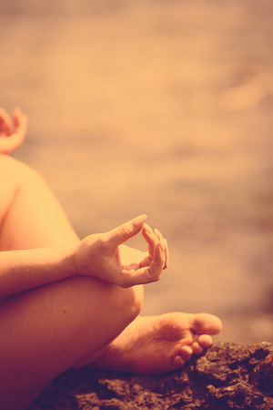 A woman doing yoga exercise and serenity  at sunsetの写真素材