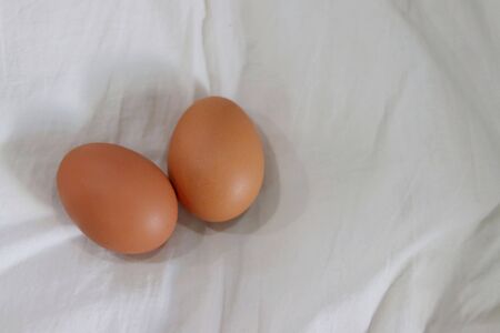 two eggs on white fabric background