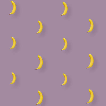 Colorful fruit pattern of yellow bananas on pastel pink background. Top view. Flat lay. Pop art designの写真素材