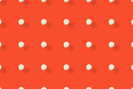 Colorful pattern of white zephyr on orange background with shadows. Marshmallow. Top view. Flat lay....
