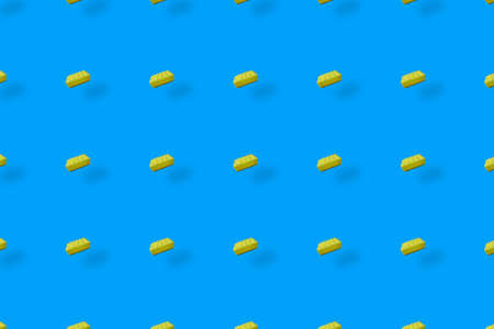 Colorful pattern of yellow kitchen sponges on blue background with shadows. Top view. Flat lay. Pop...