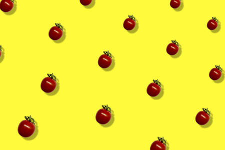 Colorful pattern of fresh red tomatoes on yellow background with shadow. Top view. Flat lay. Pop art designの写真素材
