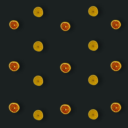 Colorful pattern of dried grapefruits and oranges slices on black background. Dried grapefruit and oranges chips. Top view. Flat lay. Pop artの写真素材