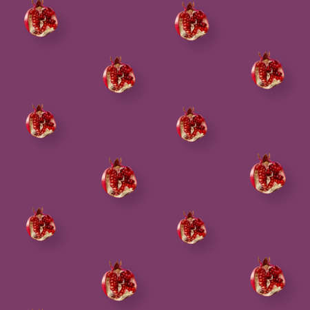 Colorful fruit pattern of fresh pomegranates on purple background. Top view. Flat lay. Pop art designの写真素材