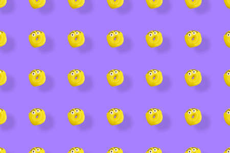 Colorful pattern of yellow glazed donuts isolated on purple background with shadows. Doughnuts. Top view. Flat layの写真素材