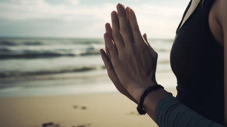 Young woman practicing yoga on the beach close-up. Created with Generative AI technologyの素材