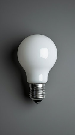 White Light Bulb Illuminating a Gray Wallの素材