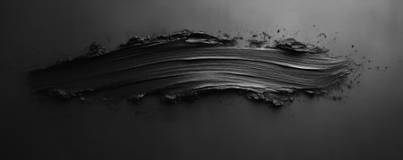Black paint brushstroke on a dark backgroundの素材