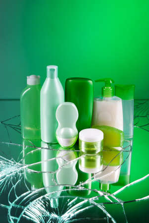 Group of empty cosmetic bottles on beautiful green mirrorの写真素材