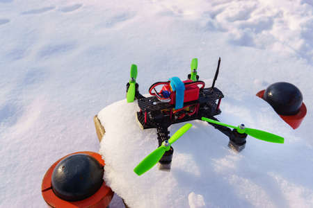 Racing quadcopter on the snow in park