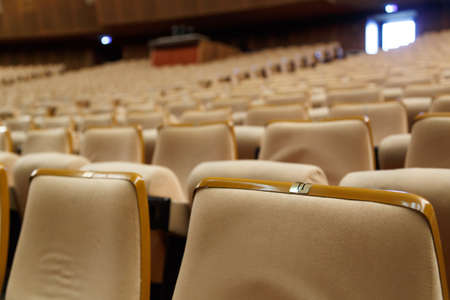 Empty cinema hall with a lot of beige armchairs, dim lightの写真素材
