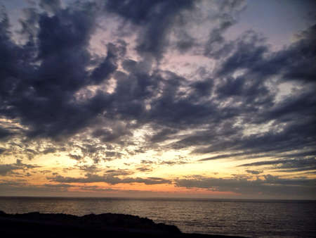 Sunset with dark clouds in the backgroundの素材