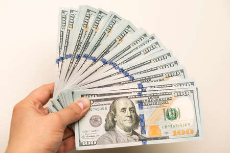 Man's hand holding hundred dollar bank notesの写真素材