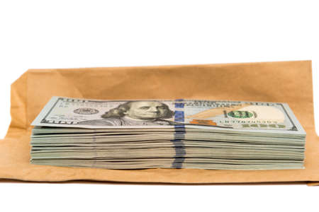 Isolated stack of hundred dollar bills on top of brown envelope