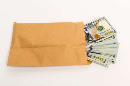 Stash of money in hundred dollar cash banknotes coming out of envelopeの写真素材