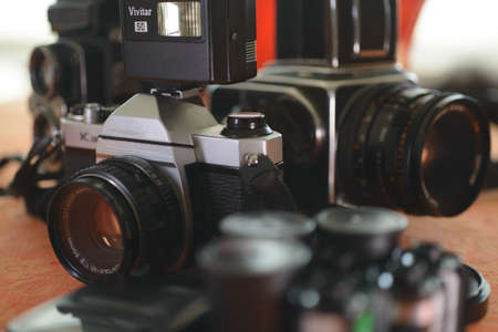 vintage photography class cameras 35 mm and 120 old camera on the table for introduction to analogue photography or photography class with cameras flash and film or magazinesの写真素材