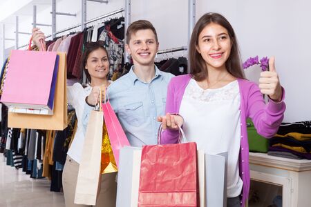 Happy young people in a clothing store with shopping bagsの写真素材