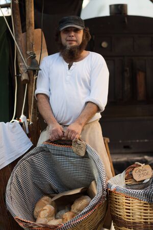 Man with a beard holding a basket with bread