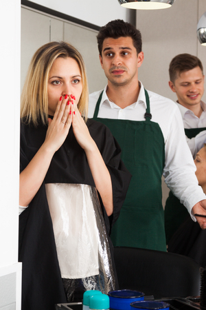 Upset young female blaming hairdresser in bad haircut hairdressing saloonの写真素材