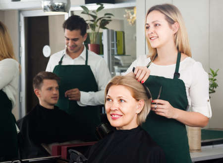 Woman hairdresser cuts woman at the hairdresser saloonの写真素材