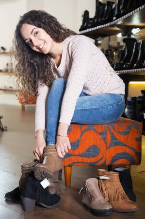 Female choosing winter women shoes in a shoe storeの写真素材
