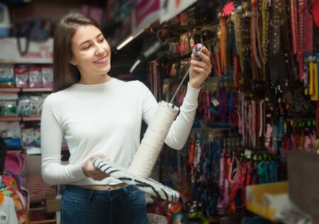 Ordinary female customer buying accessory for pet in storeの写真素材