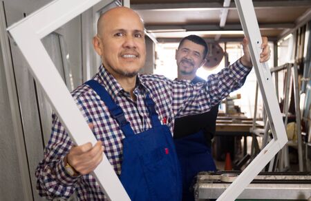bald man in a blue uniform holding in front of the window frame