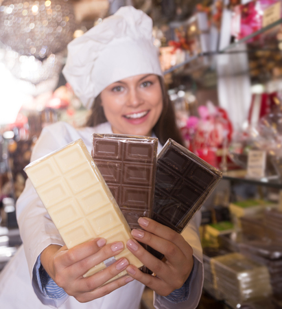 Young girl selling fine chocolates and confectionery in cafeの写真素材