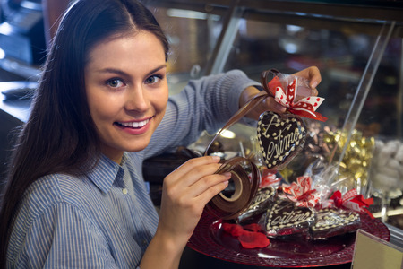 Young girl selecting fine chocolates and confectionery in cafeの写真素材