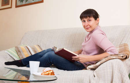 Woman reading a book at homeの写真素材