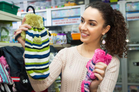 Young woman choosing canine couture and smiling in pet storeの写真素材